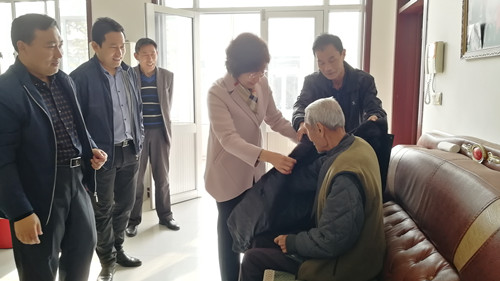 局党组成员、工会主席任永青为老人送上羽绒服.jpg